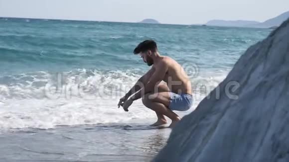 一个人坐在沙滩上孤独的年轻人视频的预览图