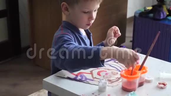 小男孩热情地在纸上用水彩作画视频的预览图