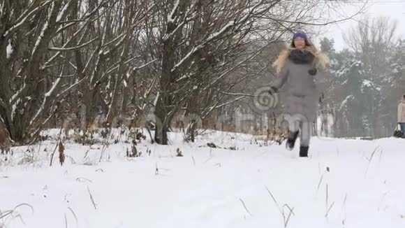 美丽开朗的女孩在雪地里遛狗视频的预览图