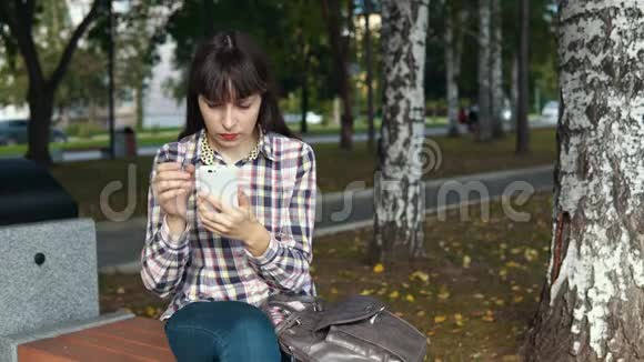 城市公园使用智能手机的年轻女性视频的预览图