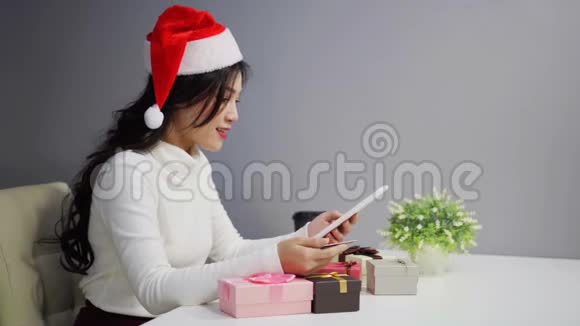 女士在网上购物圣诞礼物与数字平板电脑视频的预览图