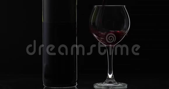 玫瑰酒红酒倒在黑色背景上的酒杯里剪影视频的预览图