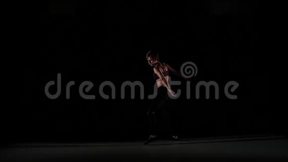 年轻女孩在黑色的阴影中轻舞视频的预览图