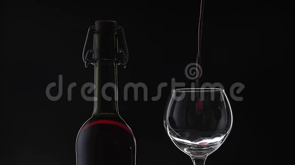 玫瑰酒红酒倒在黑色背景上的酒杯里慢动作视频的预览图