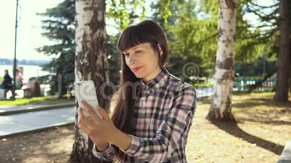 城市公园使用智能手机的年轻女性视频的预览图