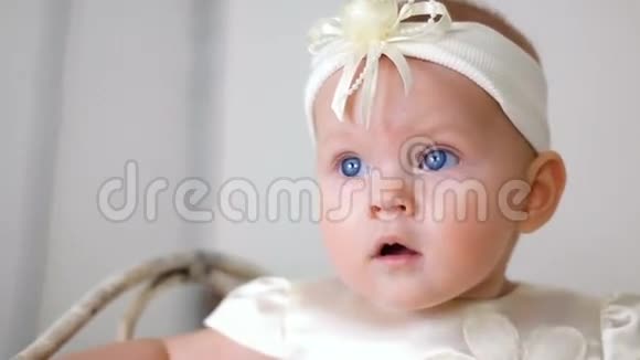 穿白色连衣裙戴头巾的女婴视频的预览图