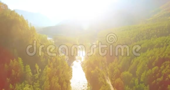 在阳光明媚的夏季早晨低空飞行在带岩石的新鲜快山河上视频的预览图