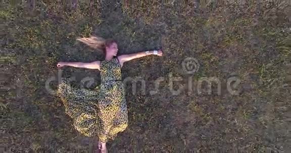 美丽的女人躺在草地上享受视频的预览图