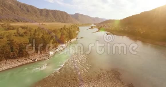 在阳光明媚的夏季早晨低空飞行在带岩石的新鲜快山河上视频的预览图