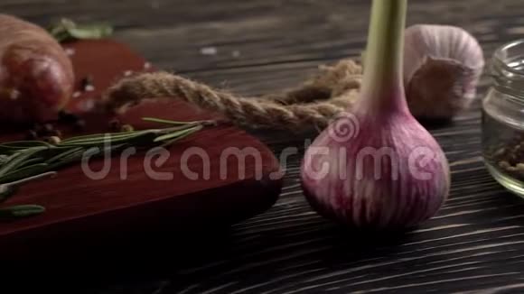 生香肠和大蒜迷迭香在木制表面视频的预览图