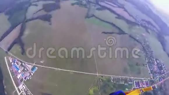 专业跳伞员在空中跳伞飞越田野森林景观体育运动视频的预览图