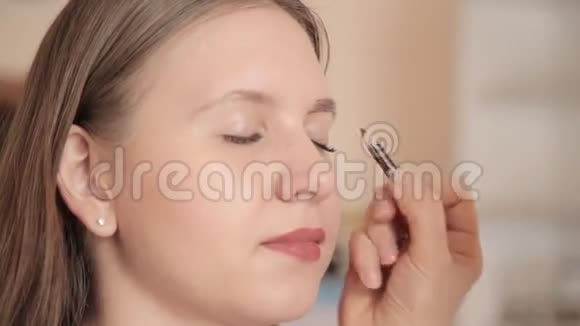 化妆师用铅笔画客户的眉毛近距离射击视频的预览图