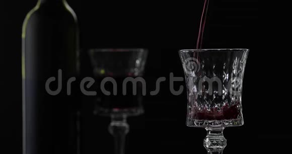 玫瑰酒红酒倒在黑色背景上的酒杯里剪影视频的预览图