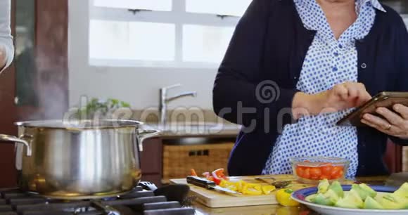 母亲和女儿在家厨房准备食物视频的预览图