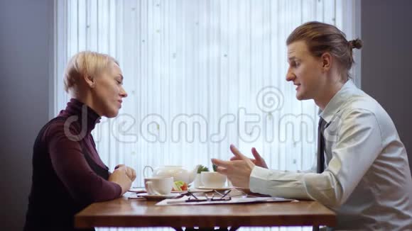 两个年轻人在一家咖啡馆里合作讨论项目一家餐馆里的女人和男人视频的预览图