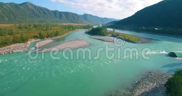 在阳光明媚的夏季早晨低空飞行在带岩石的新鲜快山河上视频的预览图