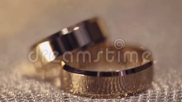 婚礼上的戒指在闪亮的表面上闪耀光线接近宏观视频的预览图