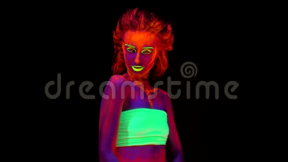 一个美丽的年轻女孩她的身体在黑色的光线下有发光的油漆一个漂亮的女人身上有黑色的紧身衣视频的预览图