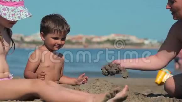 孩子们在海滩上玩沙子和水视频的预览图