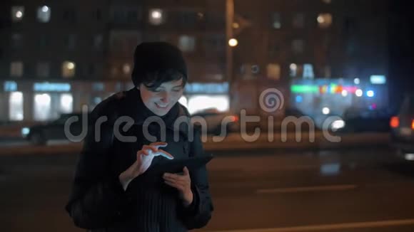 晚间城市带数字平板电脑的年轻女性视频的预览图