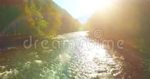 在阳光明媚的夏季早晨低空飞行在带岩石的新鲜快山河上视频的预览图