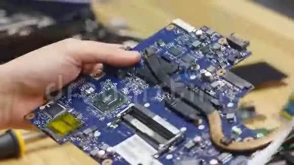 修理工拆卸笔记本电脑主板工程师在工作中修理坏电脑电子修理店技术视频的预览图
