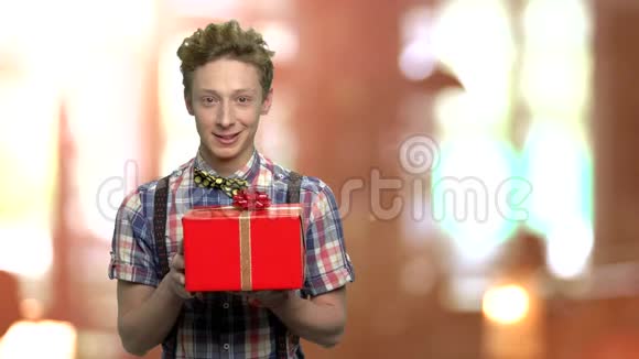 漂亮的男孩背景模糊的礼品盒视频的预览图
