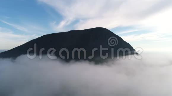 在蓝天的衬托下在云层中鸟瞰山峰山地景观视频的预览图