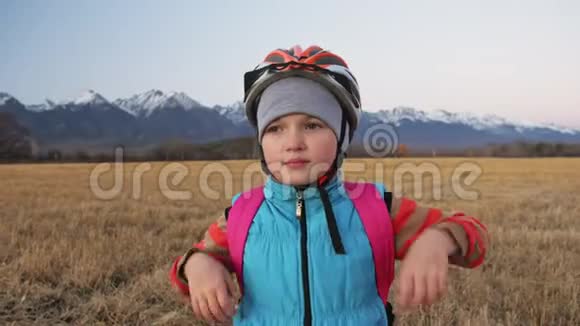 一个高加索儿童骑着自行车在麦田里行走女孩在美丽的白雪公主的背景下走着黑色橙色的自行车视频的预览图