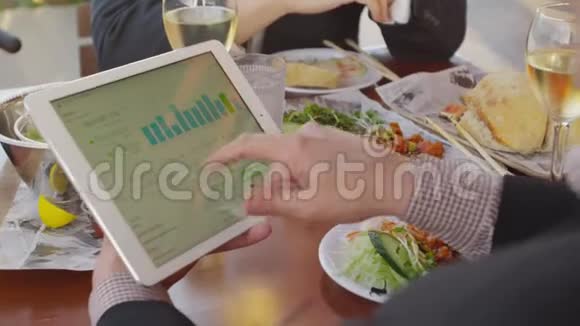 午餐时使用移动平板电脑的人视频的预览图