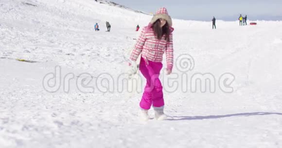 年轻女子拿着滑雪板走路视频的预览图