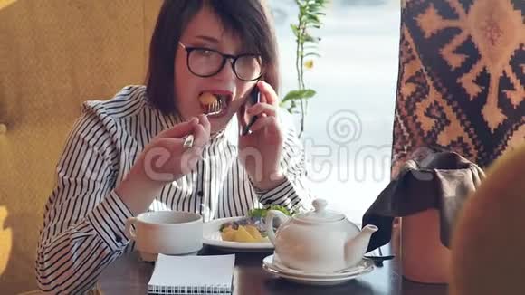 美丽的女人在午餐时休息坐在咖啡馆里商务午餐慢动作视频的预览图