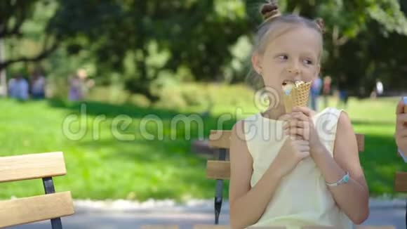 小女孩在户外吃冰淇淋夏天在户外咖啡馆视频的预览图