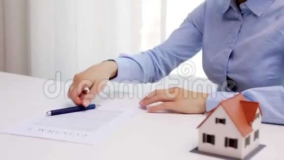 有房子模型和签字笔的女人视频的预览图