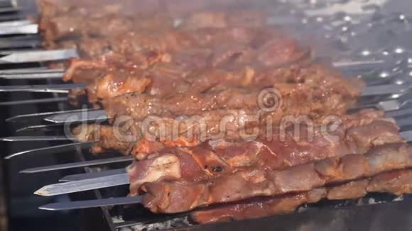 在炭烤架上用烤串烹饪多汁的猪肉视频的预览图