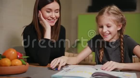 母亲和女儿做学校作业妈妈帮忙处理视频的预览图