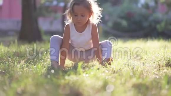 小可爱的女婴在公园的草地上做瑜伽运动视频的预览图