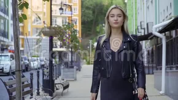 美丽的女孩走在城市街道上视频的预览图
