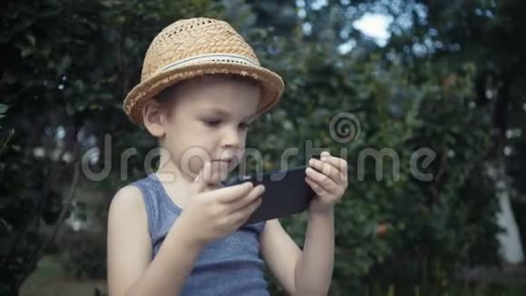 小男孩在智能手机上玩电子游戏视频的预览图