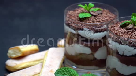 玻璃中的经典提拉米苏甜点和深色混凝土背景下的萨沃亚迪饼干视频的预览图