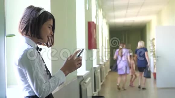 在学校概念上使用智能手机的女学生教育年轻女孩和使用智能手机站在生活方式旁边视频的预览图