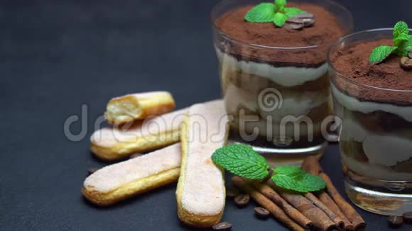 玻璃中的经典提拉米苏甜点和深色混凝土背景下的萨沃亚迪饼干视频的预览图