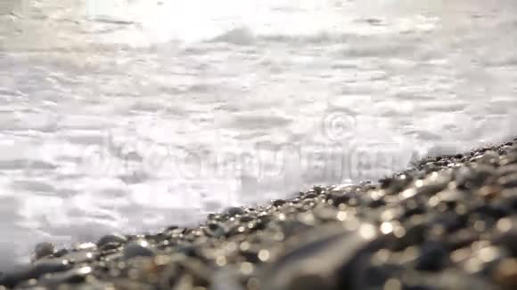 海上冲浪波浪在海岸卵石上流动视频的预览图
