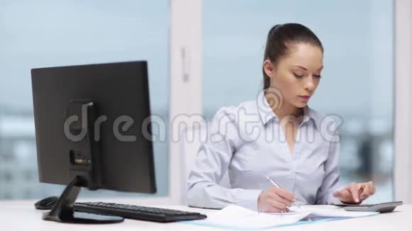有电脑文件和计算器的女人视频的预览图