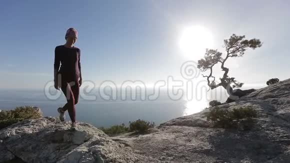 年轻女子攀登并到达山顶在美丽的风景中登上顶峰的女士视频的预览图