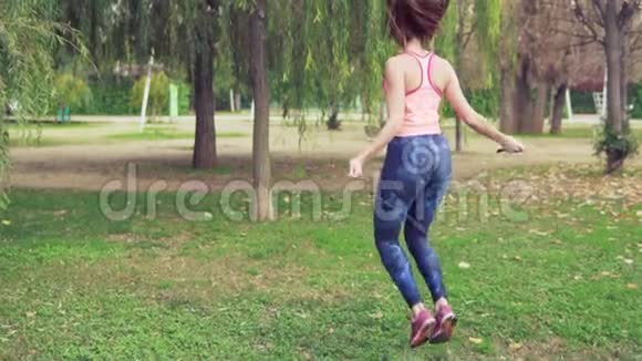 把带着跳绳的漂亮女人放在公园里视频的预览图