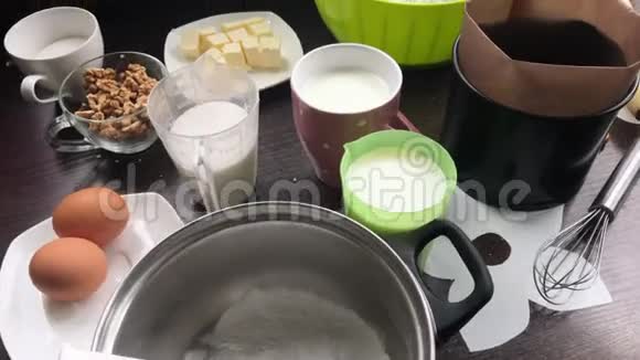 做一个饼干面包屑和牛奶果冻蛋糕桌子表面是配料和炊具视频的预览图