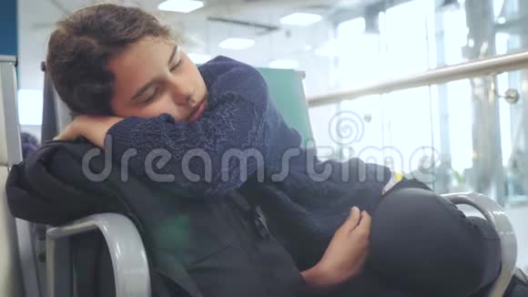 疲惫的少女少女旅行者睡在机场的生活方式上等待着飞机起飞登机门和她所有的人坐在长椅上视频的预览图