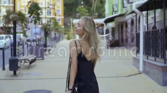 美丽的女孩走在城市的街道上视频的预览图