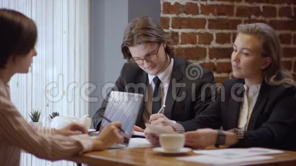 三个人一起工作在一家咖啡馆里讨论一份合同女人和男人在餐馆或咖啡里视频的预览图